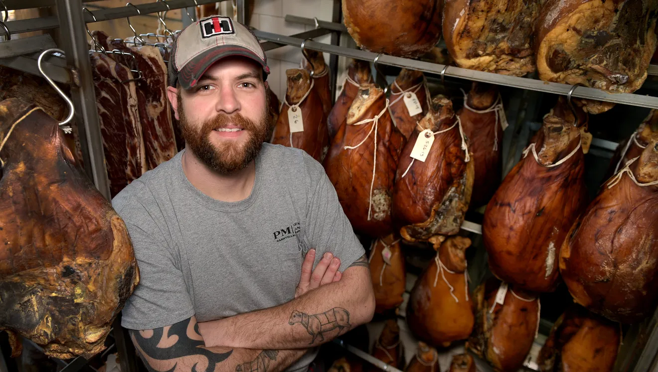 man poses in meat aging room